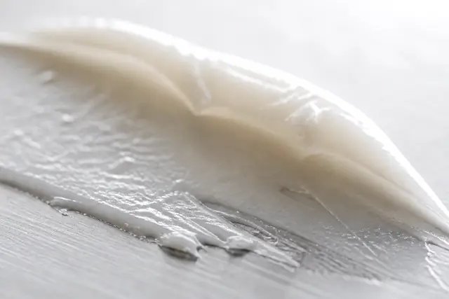 つや消しの金属のパレットに引かれた、白いバームのひとすじ